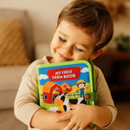 Niño abrazando el libro de fieltro de la granja cerrado